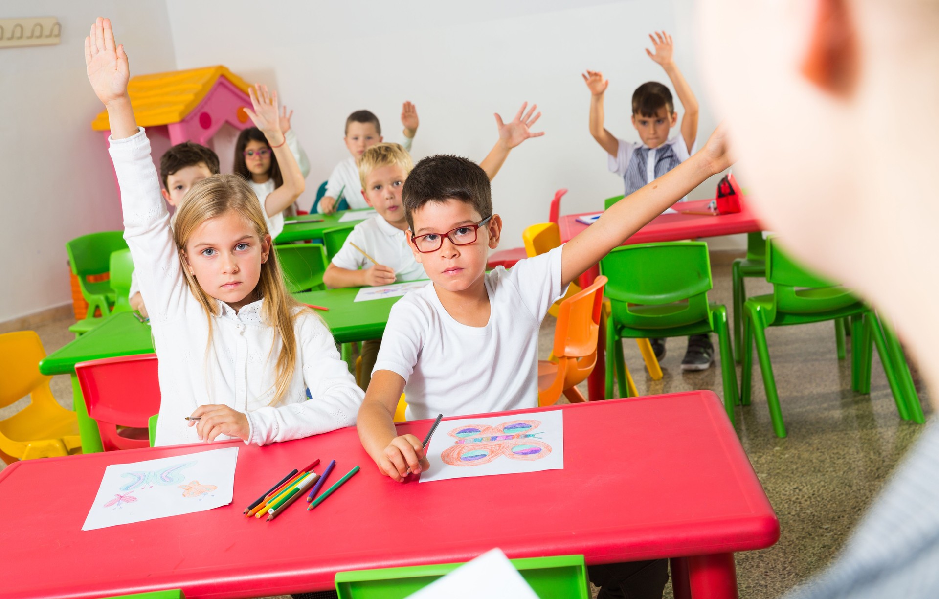 Élèves levant leurs mains dans la salle de classe